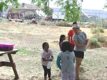 Children Playing "Spray Bottle Tag" with Youth
