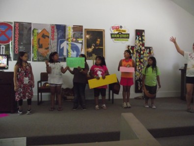 Child Holding up Sign Saying "Compassion"