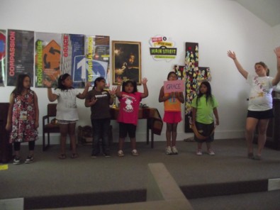 Child Holding Sign Saying "Grace"