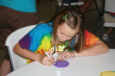 Child Drawing Smiley Face for Straw