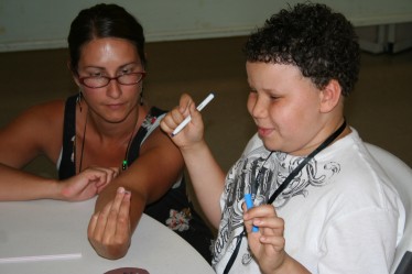 Child Creating Smiley Face for Straw