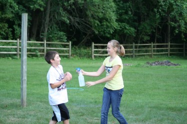 Girl "Tagging" Boy with Squirt Bottle