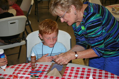 Lana Helping Child Make "Popcorn Pal" Bag