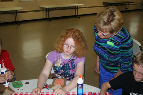 Lana Helping Child Make "Popcorn Pal" Bag