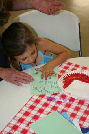 Girl Pressing Painted Hand on Paper