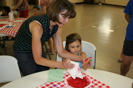 Cindy Putting Paint on Child's Hand