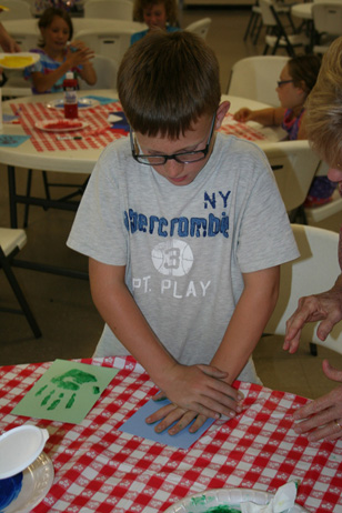 Boy Pressing Hand on Paper