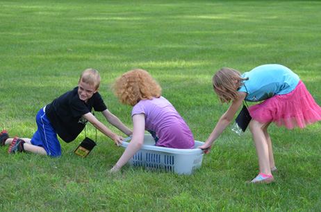 Boy Pulling, Girl Pushing Girl in Laundry Basket