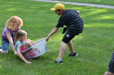 Boy Pulling, Girl Pushing Girl in Laundry Basket