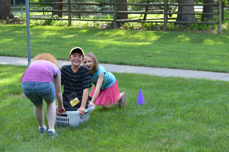 Two Girls Pulling & Pushing Boy in Laundry Basket