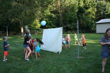 Kids Tossing the Ball Over the Sheet