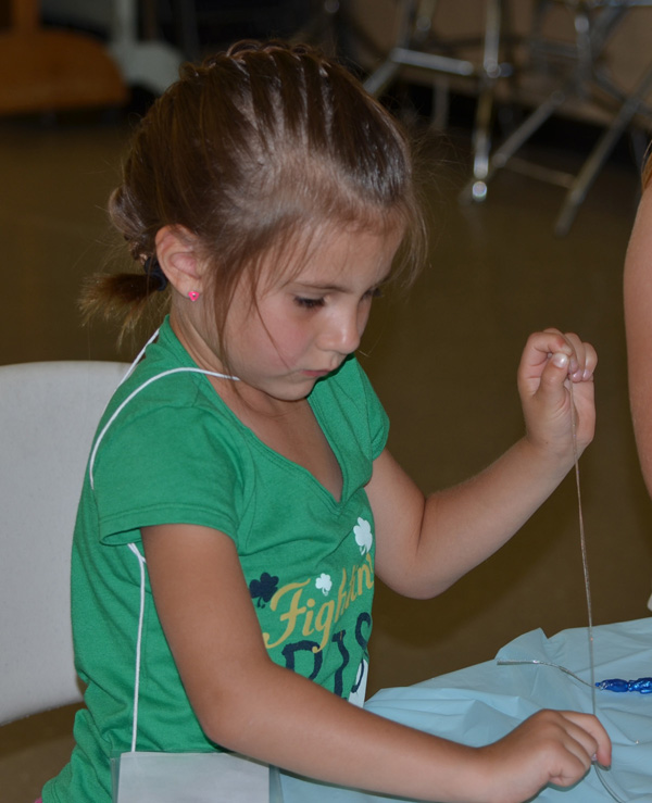 "Girl Making Necklace