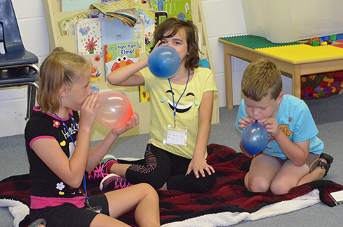 Children Blowing Up Balloons