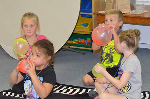 Children Blowing Up Balloons