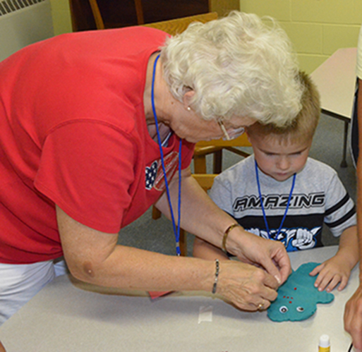 Marcia Helping Child with His Craft