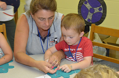 Kathy Helping Child with His Kraft