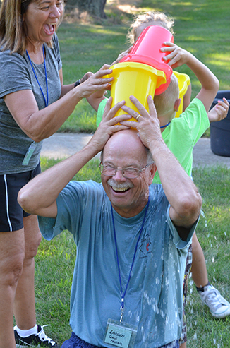 Child Passing Bucket of Water