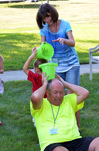 Child Passing Bucket of Water