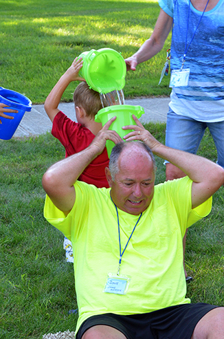 Child Passing Bucket of Water