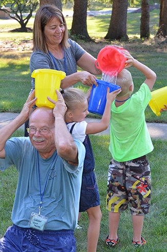 Child Passing Bucket of Water