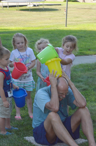 Child Passing Bucket of Water