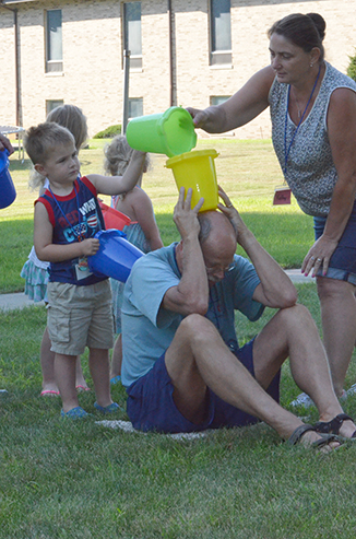 Child Passing Bucket of Water