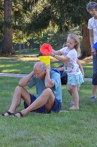 Child Passing Bucket of Water