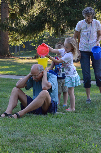 Child Passing Bucket of Water