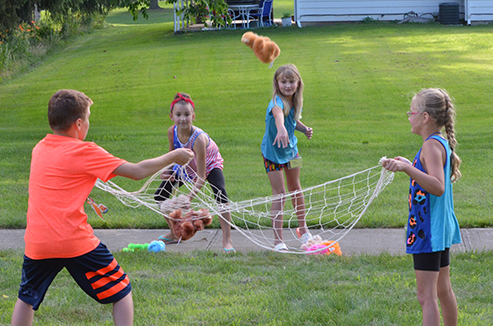 Child Tossing Stuffed Animal in Net