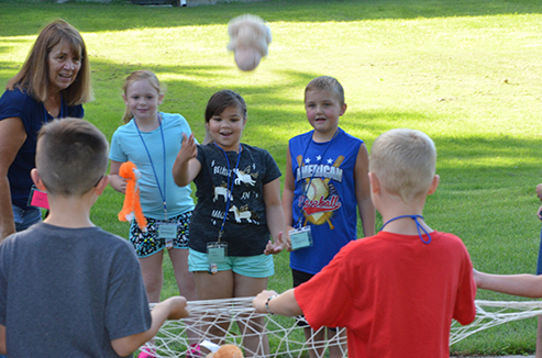 Child Tossing Stuffed Animal in Net