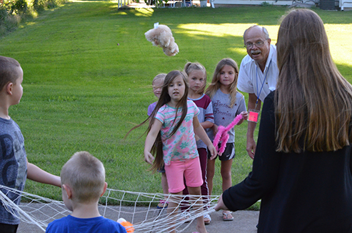 Child Tossing Stuffed Animal in Net