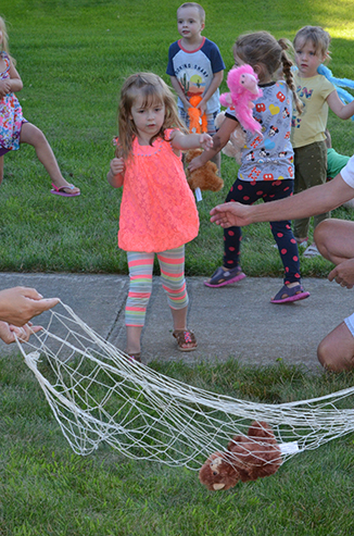 Child Tossing Stuffed Animal in Net