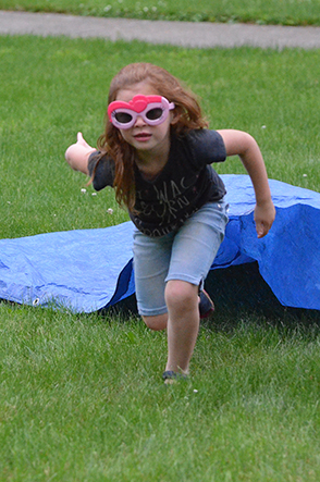 Child Emerges from Under Tarp