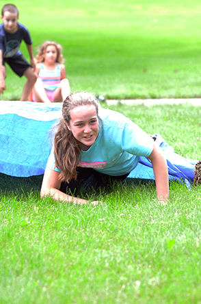 Child Emerges from Under Tarp