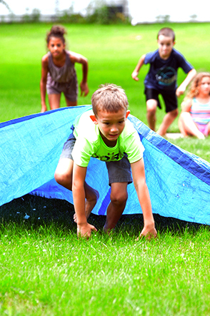 Child Emerges from Under Tarp