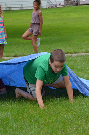 Child Emerges from Under Tarp