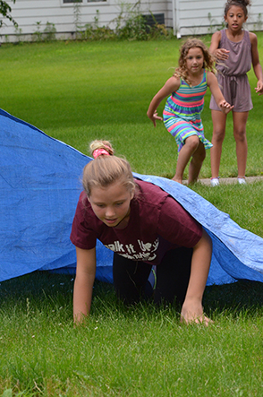 Child Emerges from Under Tarp