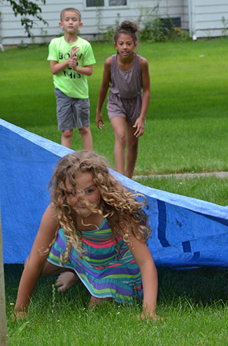 Child Emerges from Under Tarp