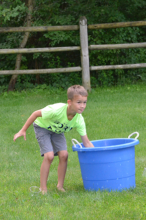 Child Dips Cup into Water