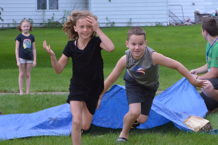 Child Emerges from Under Tarp