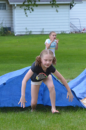 Child Emerges from Under Tarp