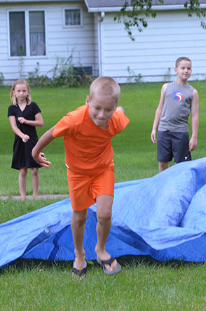 Child Emerges from Under Tarp