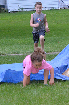 Child Emerges from Under Tarp